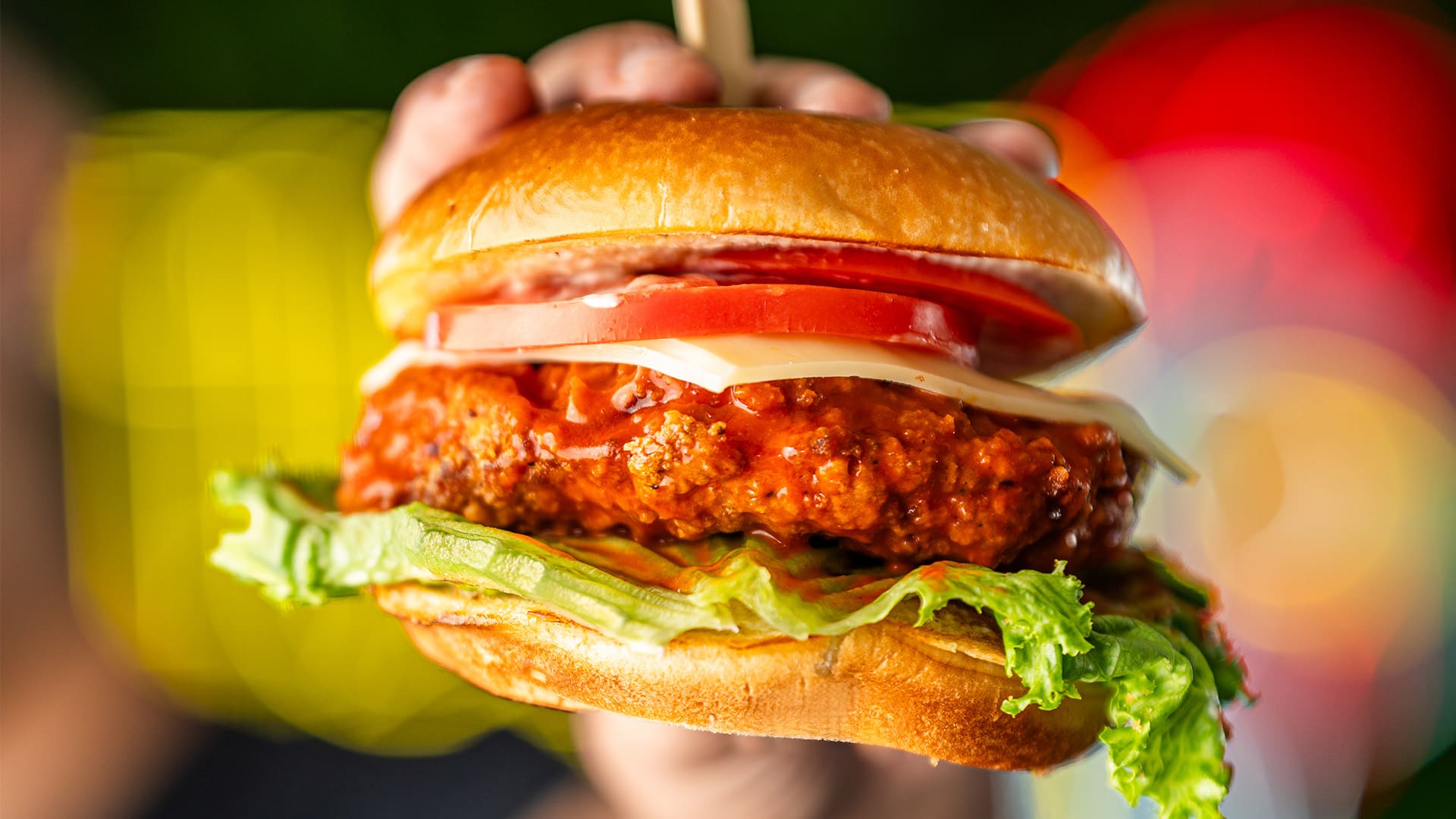 a hand holding the the best fried chicken in tucson