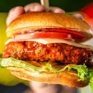 a hand holding the the best fried chicken in tucson